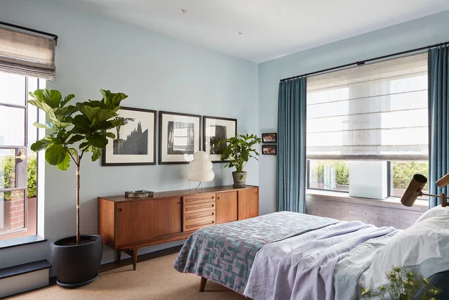 Richly layered bedroom with woad-blue tones and collected antique objects, Chelsea loft