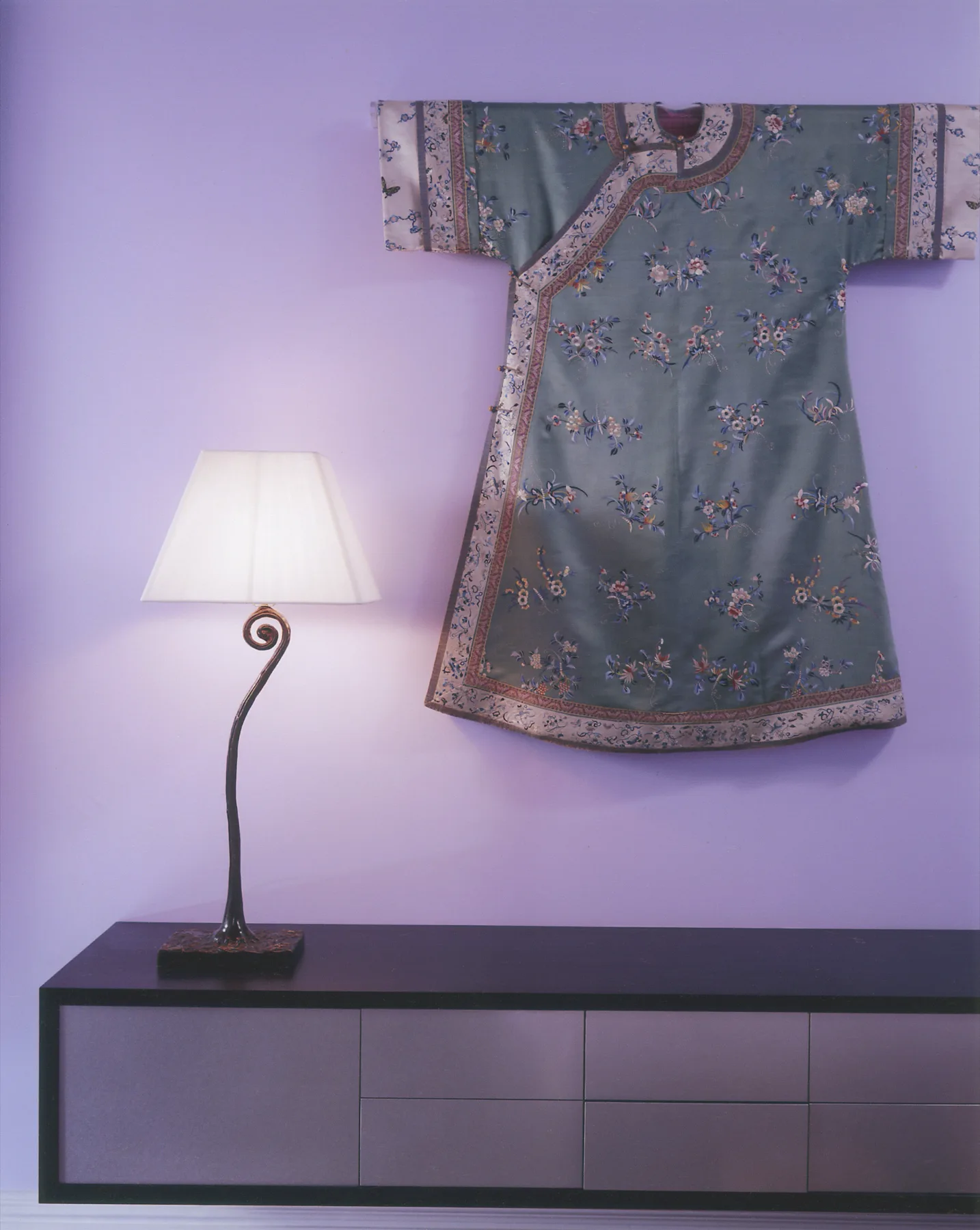 Dining area with violet and plum tones, antique furnishings and layered textiles