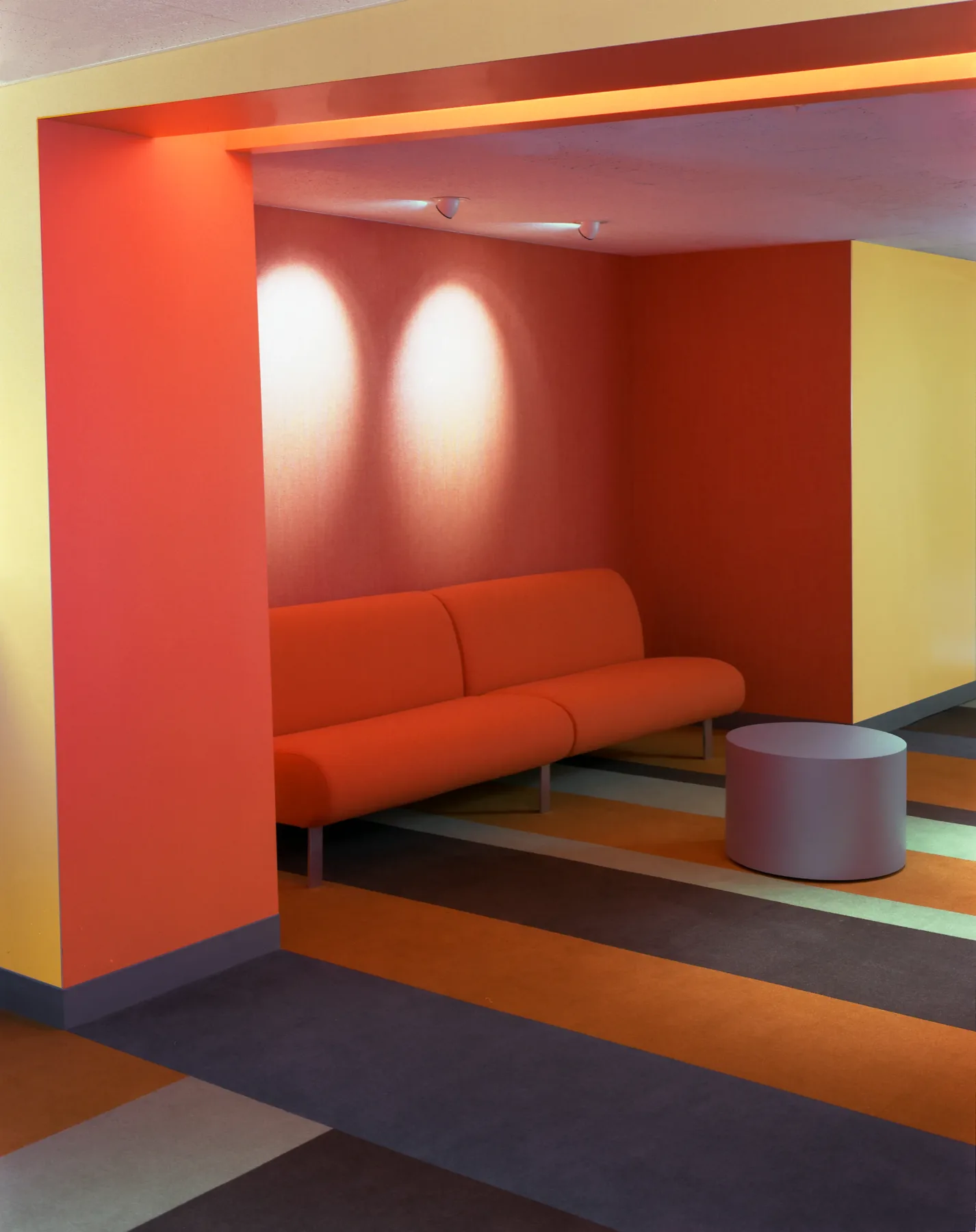 Open-plan office with warm orange tones and curated materiality, New York City