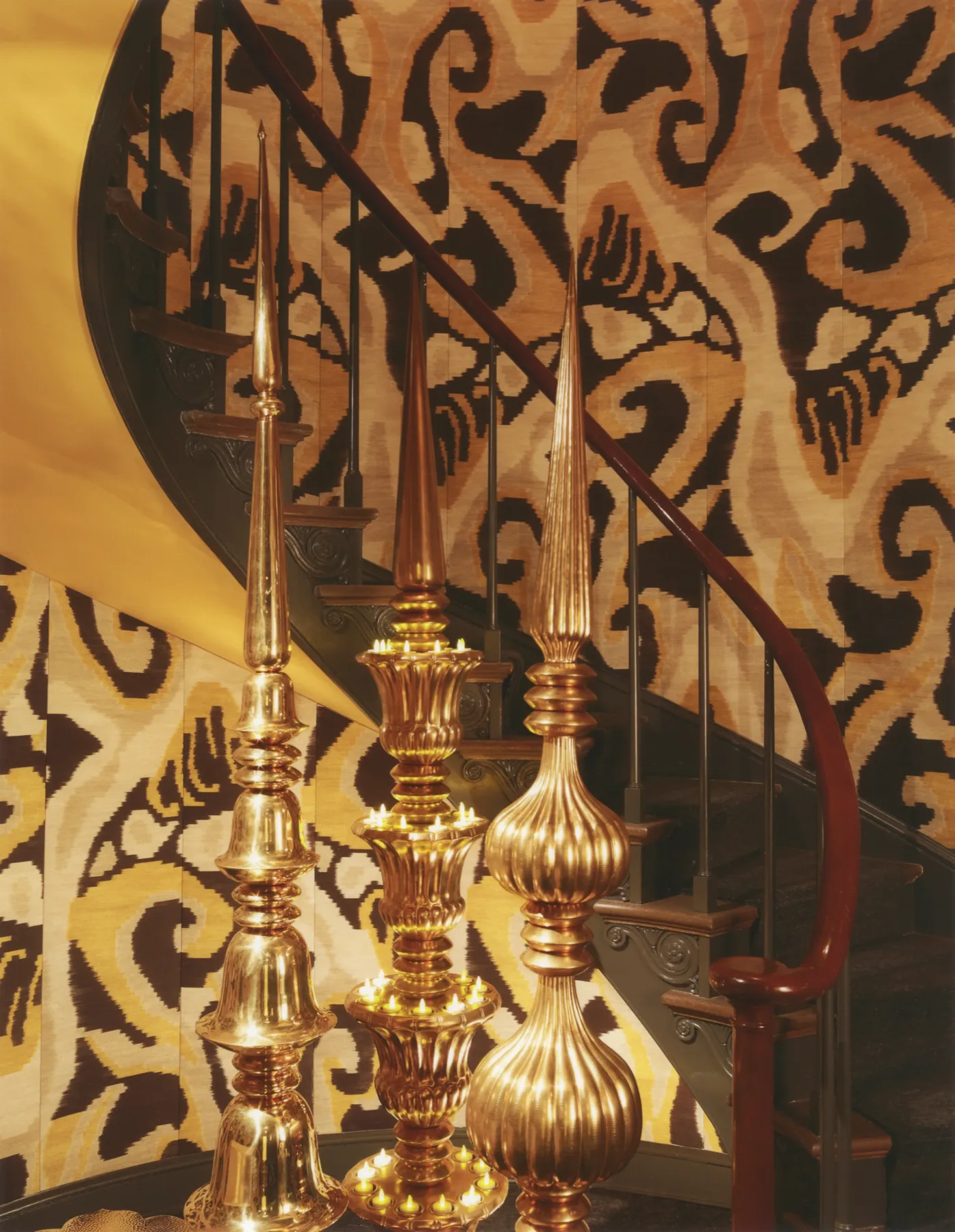 Detail of patterned textiles and gilded objects in a graphite-toned show house room
